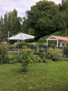 einen Garten mit einem weißen Regenschirm im Hof in der Unterkunft gîte au Pays Basque entre mer et montagne in Villefranque