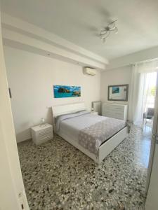 a white bedroom with a bed and a window at CASA VACANZE VITTORIA COLONNA in Ischia