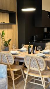 a wooden table with chairs and wine bottles on it at Apartament ONE Szklarska Poręba in Szklarska Poręba