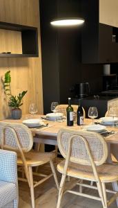 シュクラルスカ・ポレンバにあるApartament ONE Szklarska Porębaの木製テーブル(椅子付)、ワインボトル