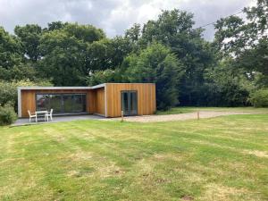 una pequeña casa de madera en un jardín con patio en Independent rural detached annexe with free private Parking en Canterbury