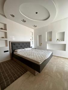 Luxueuse appartement في أغادير: غرفة نوم بسرير كبير بسقف
