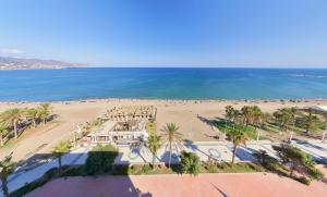una vista aérea de una playa con palmeras y el océano en Playa apartamento, en Málaga