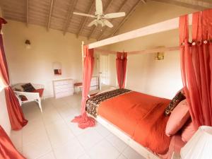 基督堂區的住宿－Terracotta Enterprise - Gated Community Home，一间卧室配有一张带红色窗帘的天蓬床
