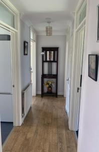 un pasillo con paredes blancas y suelo y puertas de madera en 1 Bedroom Apartment Central Basingstoke, en Basingstoke