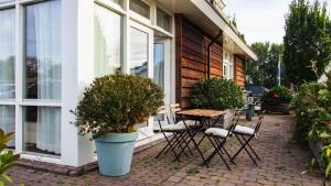 een patio met een tafel en stoelen naast een huis bij The marine apartment near Amsterdam in Kortenhoef