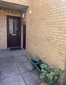 un edificio de ladrillo con una puerta y algunas plantas en 1 Bedroom Apartment Central Basingstoke, en Basingstoke