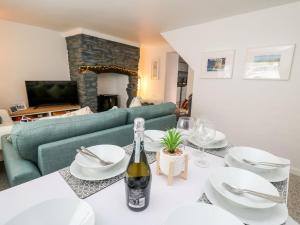 Sala de estar con mesa y botella de vino en Lane Cottage en Cardigan
