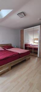 een slaapkamer met een groot bed en een spiegel bij Schöne helle Ferienwohnung in Eurasburg