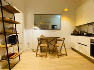 une petite cuisine avec une table et deux chaises dans l'établissement PiazzaBorsa Charme apartment, à Trieste