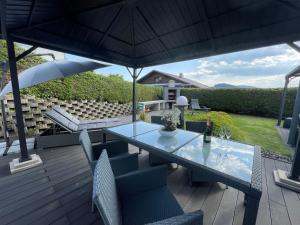 einen Tisch und Stühle auf einer Terrasse mit einem Sonnenschirm in der Unterkunft Ferienwohnung am Seeblick in Feldkirchen in Kärnten