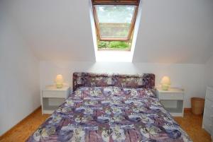 a bed in a room with two night stands and a window at Ferienpark am Darß - Apartmenthaus 1 in Fuhlendorf
