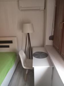 a bedroom with a bed and a table and a lamp at Apartman Vojka in Višegrad