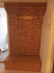 a brick wall in a room with a wooden drawer at Apartman Vojka in Višegrad