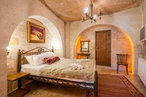 a bedroom with a bed in a room with an arch at Nomads Cave Hotel & Rooftop in Goreme