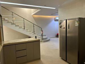 a kitchen with a staircase and a stainless steel refrigerator at Riyadh Salman Villa فيلا in Riyadh