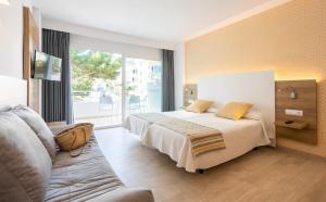 a hotel room with a bed and a couch at Casablanca Apartments, Santa Ponsa in Santa Ponsa