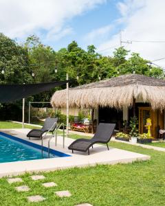 a resort with two chairs and a swimming pool at Entire farm place w/ 2 casitas & dipping pool in Lubo
