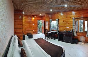 - une chambre avec un lit et un bureau dans l'établissement Aaroham By Aamod Luxury Cottage Resort, à Dalhousie