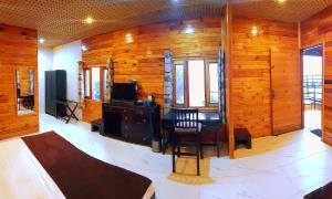 a room with wooden walls and a desk and a chair at Aaroham By Aamod Luxury Cottage Resort in Dalhousie