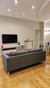 ein Wohnzimmer mit einem Sofa und einem Flachbild-TV in der Unterkunft Toledo Suites in Neapel