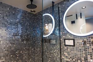 a bathroom with a shower with two mirrors at Villa Hermes in Anafiotika Athens ! in Athens