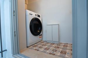 a washing machine in a laundry room with a tile floor at Villa Hermes in Anafiotika Athens ! in Athens