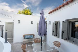 a patio with a table and an umbrella at Villa Hermes in Anafiotika Athens ! in Athens
