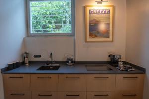 a kitchen with a sink and a window at Villa Hermes in Anafiotika Athens ! in Athens