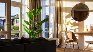 a living room with a black couch and a plant at The marine apartment near Amsterdam in Kortenhoef