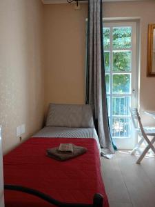 a bed in a bedroom with a red blanket on it at AFFITTACAMERE PIAZZA UNITA' in Monfalcone