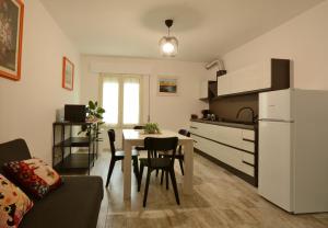 a kitchen and living room with a table and a white refrigerator at CivicoNove in Piombino