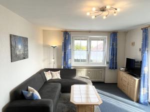 a living room with a couch and a tv at Gästehaus Walter in Fichtelberg