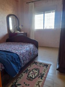 a bedroom with a bed and a mirror and a rug at Appartement au centre de la ville de Meknès in Meknès