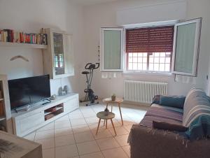 a living room with a couch and a tv at Sisters Home in Bologna