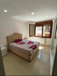 a bedroom with a bed with red roses on it at Appartement à el ACHOUR promotion CMB parc dounia in El Achour