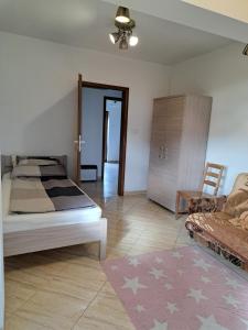 ein Schlafzimmer mit einem Bett, einem Sofa und einem Teppich in der Unterkunft Ogrodowe Noclegi 2 