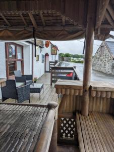 een houten terras met een tafel en stoelen erop bij Loch's Heaven 67 in Balminnoch