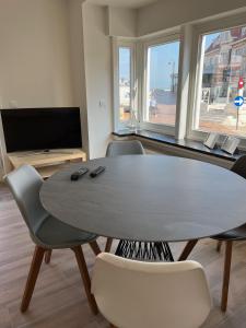 デ・ハーンにあるDe Haan App 1のリビングルーム(テーブル、椅子、テレビ付)
