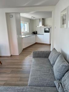 a living room with a couch and a kitchen at De Haan App 1 in De Haan +1 photo