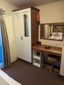 a bedroom with a desk and a mirror and a bed at Loch's Heaven 67 in Balminnoch