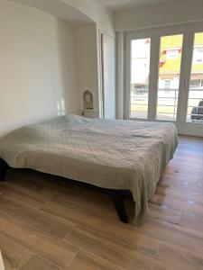 ein großes Bett in einem Schlafzimmer mit Holzboden in der Unterkunft De Haan App 1 in De Haan