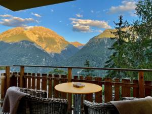 a table and chairs on a balcony with mountains at Costa dad Archas B5 in Sent