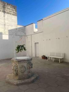 une fontaine avec une plante devant un bâtiment dans l'établissement Casa vacanza “La Maison de famille”, à Surbo