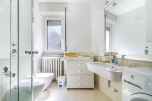 uma casa de banho branca com um lavatório e um WC em DomusMi Gozzano-4 em Milão