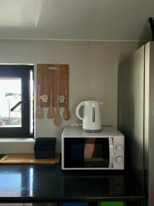 a microwave sitting on top of a counter in a kitchen at Behappy Lodge & Brunch in Esmoriz
