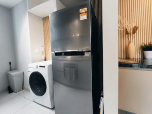 uma cozinha com um frigorífico de aço inoxidável e uma máquina de lavar roupa em Kuala Lumpur Datum Jelatek - KLCC view - Infont LRT And 5 Minutes to KLCC -Near by Gleneagles em Kuala Lumpur
