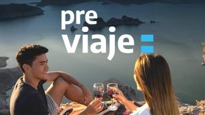 a man and woman sitting on a beach drinking wine at Design 440 in San Carlos de Bariloche