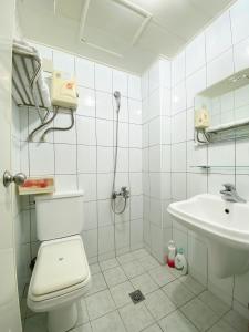 a white bathroom with a toilet and a sink at Fengjia 101 in Taichung