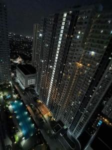 vistas a una ciudad por la noche con edificios altos en Cozy 1 bedroom with Balcony, en Manila